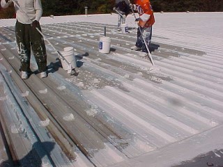 Crew members of Roof Menders dab isolated fasteners